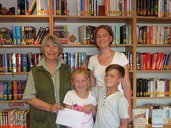 Stellvertretend für die vielen Leser nahmen Paula und Linus sowie Silke Hehn und Barbara Seufert (fehlt auf dem Foto) vom Team der Katholischen Öffentlichen Bücherei Aschach von Heidi Andriessens eine Spende in Höhe von 200 Euro entgegen.  Foto: Barbara Seufert