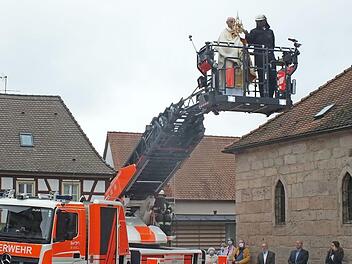 Pfarrer Helmut Hetzel spendete den Eucharistischen Segen von der Drehleiter der Feuerwehr aus. Foto: Manfred Welker