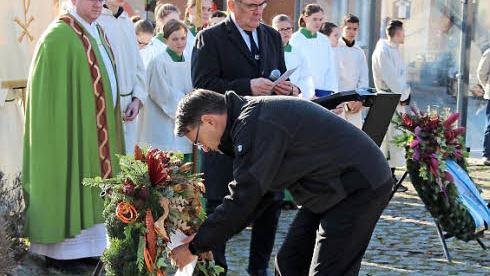 Pfarrer Ringer, Karsten Fischkal und G&uuml;nter Brehm. B&uuml;rgermeister Fischkal legt den Kranz nieder. Foto: Johanna Blum