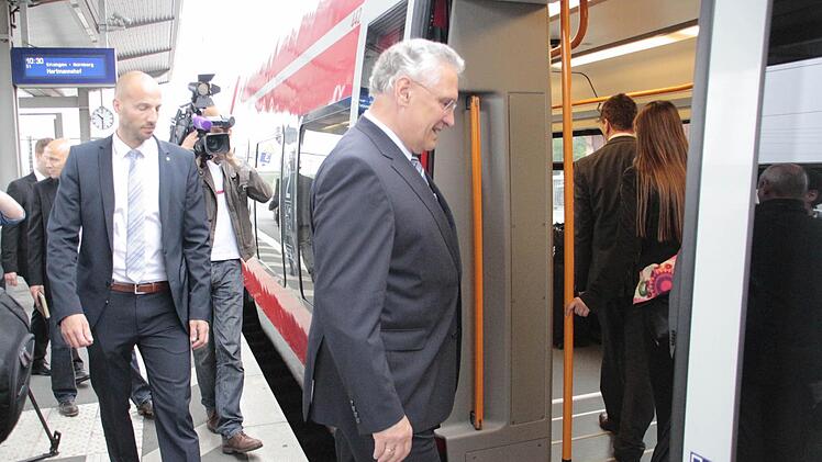 Joachim Herrmann steigt im Bahnhof Forchheim in den Zug ein - ein kleiner Schritt für den Minister, ein großer für die Bürgerinitiative, die um einen S-Bahn-Halt Forchheim-Nord kämpft. Foto: Josef Hofbauer