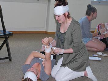 Theresa Müller legt einer Mitschülerin einen Druckverband am Unterarm an.  Foto: Manfred Mellenthin
