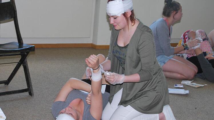 Theresa Müller legt einer Mitschülerin einen Druckverband am Unterarm an.  Foto: Manfred Mellenthin