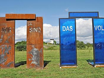 Zwei Tore mit starker Symbolkraft von Jimmy Fell. Im Hintergrund ein ehemaliger Überwachungsturm.