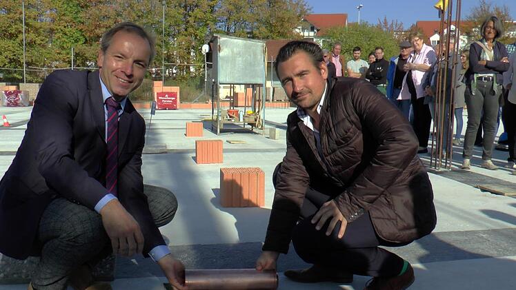 Bürgermeister Matthias Schneider (links) und Architekt Sebastian Pollach legten zusammen die Zeitkapsel in die dafür vorgesehene Öffnung im Boden.Christian Licha