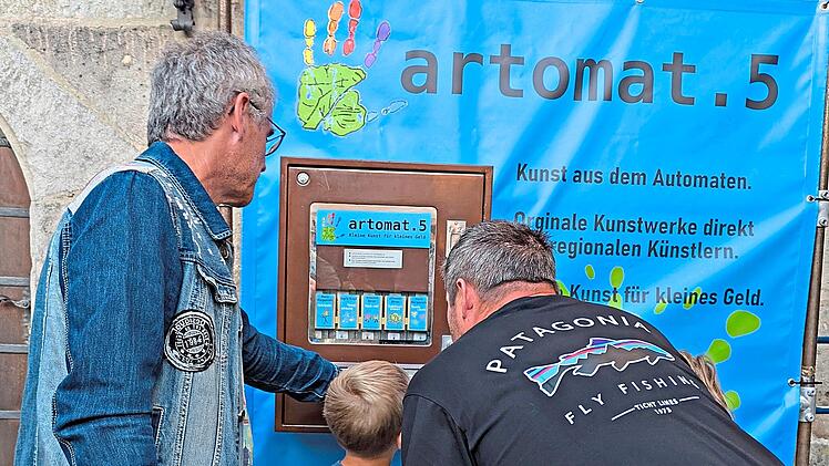 Was da wohl rauskommt? K&uuml;nstler Johannes Birzer erkl&auml;rt Neugierigen den Kunstautomaten.