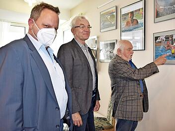 OB Lehmann (links) und Manfred Str&ouml;hlein (rechts) bewundern die Wassersportfotografien von Karl Heinz Weber.