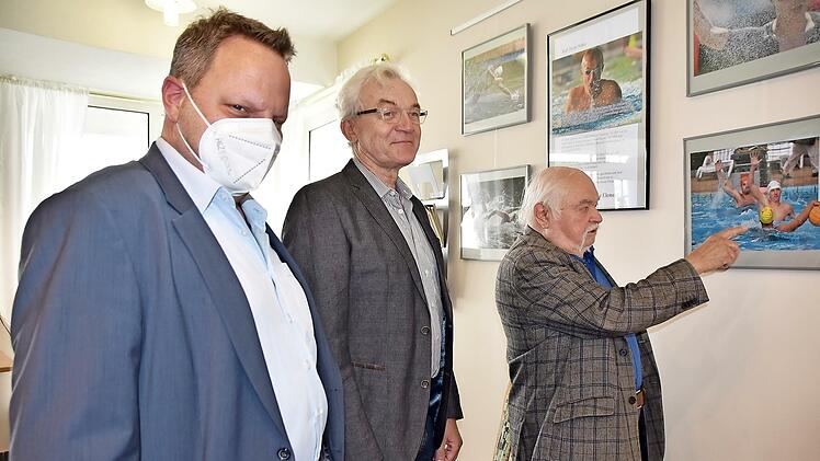 OB Lehmann (links) und Manfred Ströhlein (rechts) bewundern die Wassersportfotografien von Karl Heinz Weber.