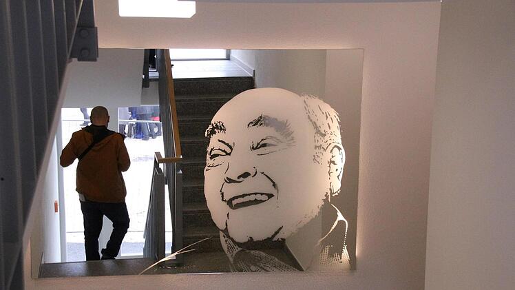 Otto Waldrich blickt aus einer großen Glaswand ins Treppenhaus in seinem neuen Studentenwohnheim.