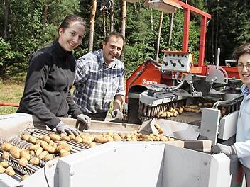 Maresa, Werner und Annette Schleicher (von links) ernten die Kartoffeln, die auf insgesamt elf Hektar gewachsen sind, mit dem Vollernter. Fotos: Julia Schilling