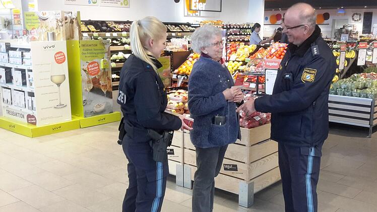 "So geht es nicht", sagt Polizeihauptkommissar Manfred Schneider (rechts) zu Helma Ritter (Bildmitte), die auf diesem gestellten Foto ihre Geldbörse zu Demonstrationszwecken einfach in die Jackentasche gesteckt hat. Polizeioberwachtmeisterin Vanessa Wießner beobachtet die Szene. Nun zog die Polizei die Bilanz der Rosenmontags-Aktion. Foto: Rolf Pralle