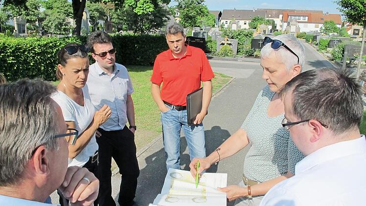 Claudia Kühnel präsentiert ihre Skizzen an Ort und Stelle, links im Bild wären Urnengemeinschaftsanlagen denkbar.  Foto: Stadt Hallstadt