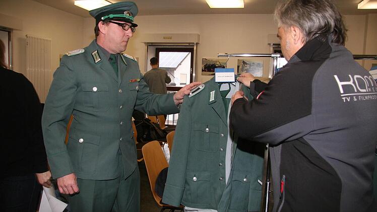 Kama Media-Chef Axel Klawuhn (rechts) hilft Harald Schieber bei der Ankleide.