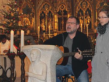 Frank und Lea Ramming tragen im Weihnachtsgottesdienst den Pop-Song "Hymn" von Barclay James Harvest vor; links Pater Thomas Muttam.  Foto: Bernhard Kuhn