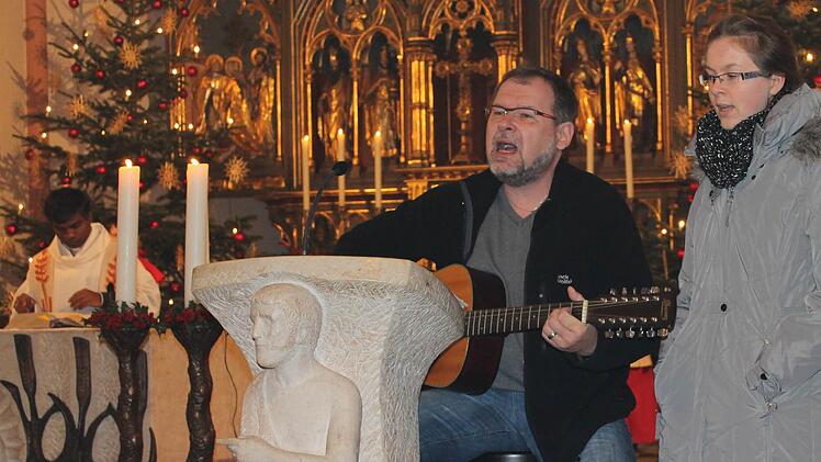 Frank und Lea Ramming tragen im Weihnachtsgottesdienst den Pop-Song "Hymn" von Barclay James Harvest vor; links Pater Thomas Muttam.  Foto: Bernhard Kuhn