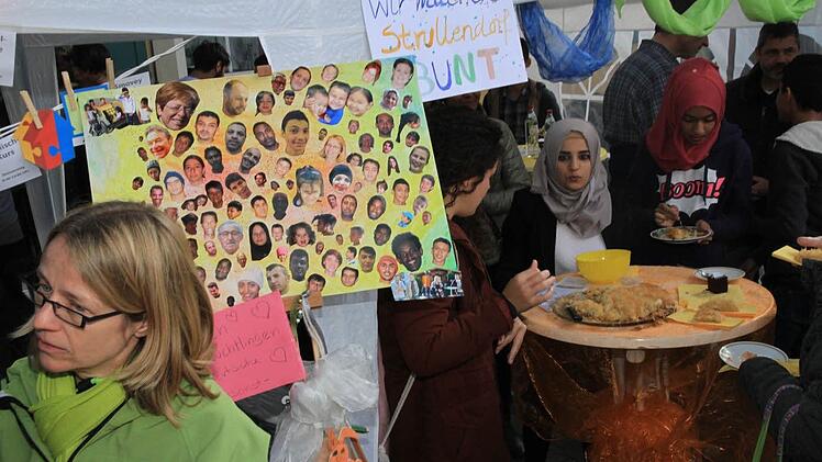 "Wir machen Strullendorf bunt": Ehrenamtliche und Flüchtlinge am gemeinsamen Stand in der Lindenallee. Foto: Bertram Wagner