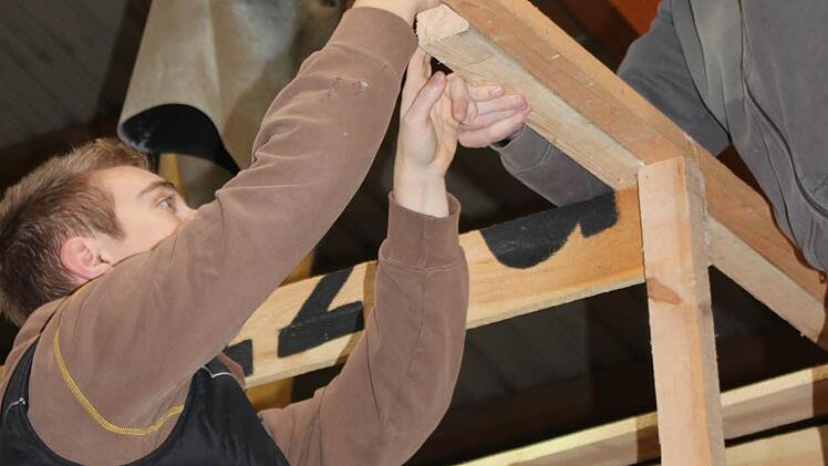 Sand: Christoph Ellmann (rechts) bringt ein Holzbrett an. Julian Woitek (links) hilft. Foto: Mattheus