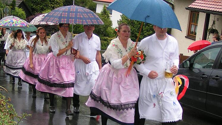 Die Tanzpaare beim "Madla-zamspieln" unter Regenschirmen.