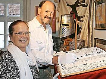 Maria und Fritz Lang tragen sich in das als Codex gestaltete "Goldene Buch" des Heimatvereins ein.  Foto: Werner Vogel