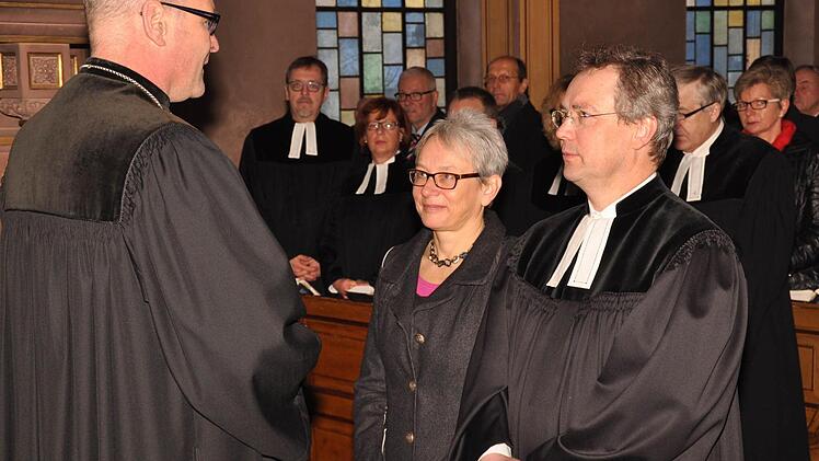 Dekan Oliver Bruckmann (links), in seiner Funktion als Dekan des Dekanatsbezirkes Schweinfurt, entpflichtet Pfarrer Jochen Wilde von seinen Pflichten Pfarramtsführer der evangelischen Erlösergemeinde Bad Kissingen und seine Ehefrau Astrid als Religionslehrerin. Foto: Peter Klopf