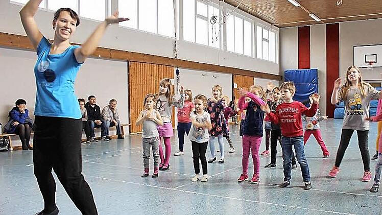Katarina Motschmann (links) macht die Salsa-Schritte vor, die Kinder machen sie nach. Auf Perfektion kommt es beim Probetraining in der Kurt-Heller-Halle überhaupt nicht an. Die Kinder sollen erst einmal Spaß am Tanzen entwickeln.  Foto: Ulrike Nauer