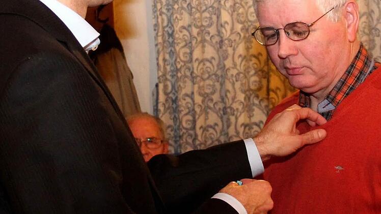 Stefan Müller steckt Bernhard Huber die Ehrennadel an.