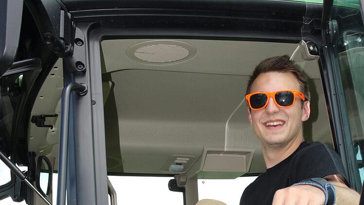 Der zwei jährige Jonas  hat sich hinter das  Lenkrad eines großen Traktors gesetzt. Tim von der Landjugend zeigt ihm den Traktor. Foto: Michael Stelzner