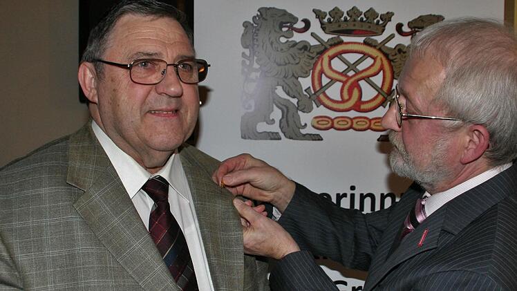 Innungsobermeister Anton Hesselbach steckt Oswin Storath (links) die Ehrennadel des Goldenen Meisterbrief an.  Foto: Vogel