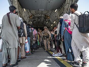Soldaten geleiten Menschen für die Evakuierung an Bord eines Militärtransportflugzeugs. Auch die Ortskräft, die jetzt in Kulmbach leben, wurde von einer Militärmaschine nach Europa ausgeflogen. Foto: Senior Airman Brennen Lege/U.S. Air Force/AP/dpa