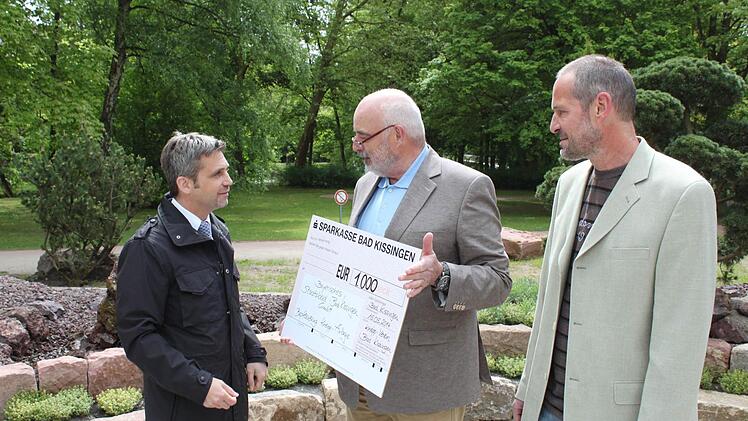 Schecküberreichung: Kurdirektor Frank Oette, Vorsitzender Anton Seuffert und Martin Christ, Chef der Kurgärtnerei. Foto: Thomas Mäuser