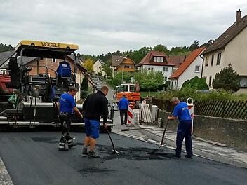 Letzte manuelle Vorbereitungen für die abschließende Feinteerschicht in der Bieberbacher Straße. Der Straßenfertiger steht schon bereit. Foto: Klaus Oelzner