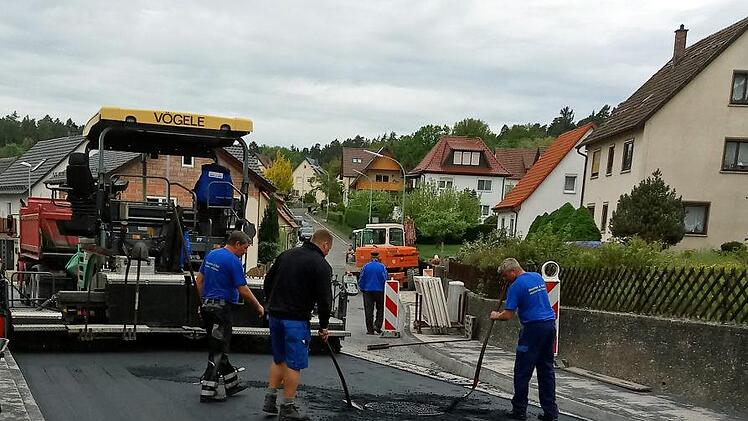 Letzte manuelle Vorbereitungen für die abschließende Feinteerschicht in der Bieberbacher Straße. Der Straßenfertiger steht schon bereit. Foto: Klaus Oelzner