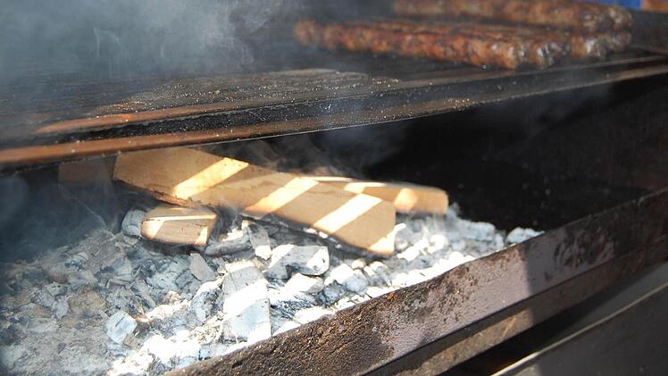 Die Brater auf dem Coburger Marktplatz befolgen die Empfehlung der Fleischer-Innung und bereiten die Bratwürste - vorerst - auf Buchenholz statt auf Kiefernzapfen zu. Foto: Oliver Schmidt