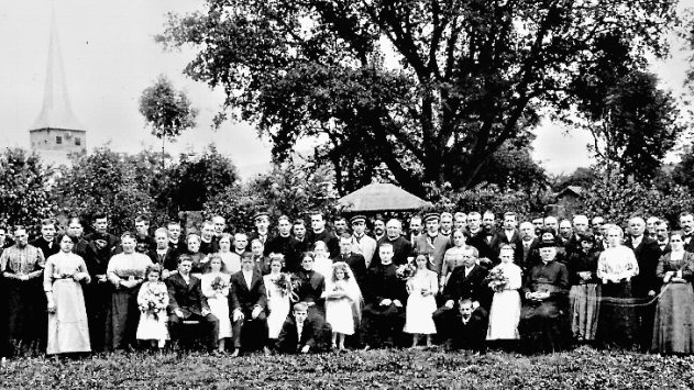 Ein Foto aus den besseren Tagen des Baumes: Die Verwandten und Ehrengäste bei der Primiz von Peter Ochs, Sohn von Lehrer Johann Ochs (Mitte sitzend), reihten sich 1912 im Lehrersgarten zu einem Erinnerungsbild auf. Im Hintergrund die damals schon imposante Maurerseiche von Neukenroth.  Repro: Gerd Fleischmann