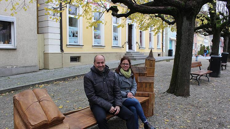 Auf die Sage vom Stadtwald bezieht sich die Holzskulptur unter den Linden. Praktisch, dass man darauf auch sitzen kann. Im Bild Bürgermeister Johannes Krapp und seine Stellvertreterin Patricia Hanika Evi Seeger