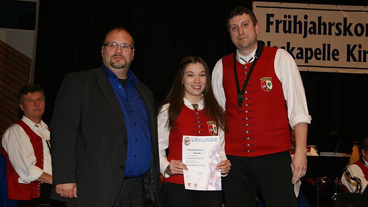 Ralf Dicker und Alexander Kneuer hefteten der Klarinettistin Tina Zimmermann das bronzene Abzeichen nach bestandener D1-Prüfung an.