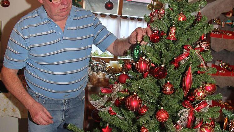 Glasbläser Egon Müller-Blech zeigt, wie die Essiggurke im Baum versteckt wird. Möglichst an einer Stelle, an der sie nicht gleich entdeckt wird.