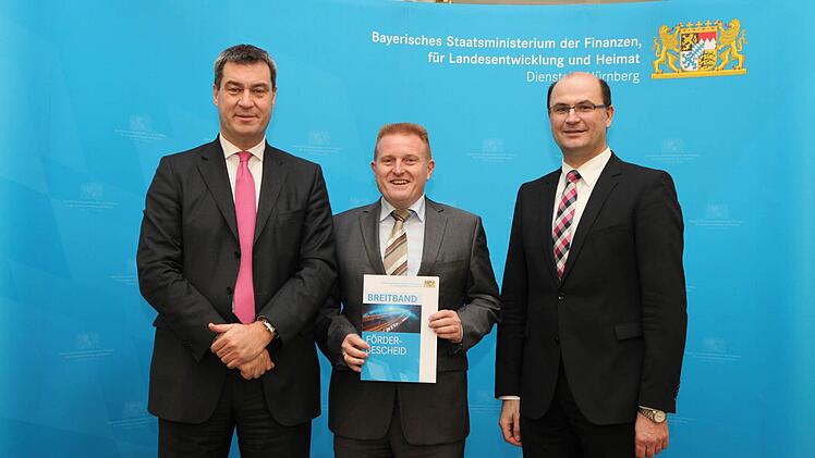 Matthias Klement (Mitte) hat den Förderbescheid aus den Händen von Staatsminister Markus Söder entgegengenommen. Rechts: Albert Füracker ,Staatssekretär im Bayerischen Staatsministerium der Finanzen, für Landesentwicklung und Heimat. Foto: Bayerisches Finanzministerium