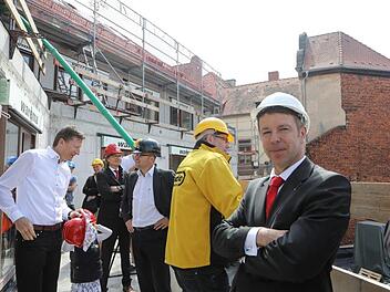 Zufriedene Gesichter auf dem Balkon einer neuen Wohnung. Im Vordergrund blickt Thomas Endres, Mitglied des Vorstandes der Sparkasse Bamberg, gelöst in die Kamera. Barbara Herbst