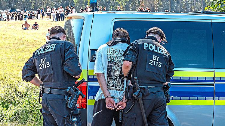Ein Teilnehmer wird von Polizeibeamten festgenommen.