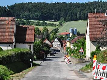 Am Freitag standen in der Altensteiner Straße in Junkersdorf Warnbaken und Absperrgitter am Straßenrand. Sie wurden wegen der momentanen Verlegung der Glasfaserleitungen für DSL aufgestellt. Die Straße soll demnächst eine neue Asphaltschicht erhalten, hat der Gemeinderat Pfarrweisach am Donnerstagabend beschlossen. 22 000 Euro soll die neue Decke kosten. Foto: Foto: Simon Albrecht