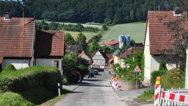 Am Freitag standen in der Altensteiner Straße in Junkersdorf Warnbaken und Absperrgitter am Straßenrand. Sie wurden wegen der momentanen Verlegung der Glasfaserleitungen für DSL aufgestellt. Die Straße soll demnächst eine neue Asphaltschicht erhalten, hat der Gemeinderat Pfarrweisach am Donnerstagabend beschlossen. 22 000 Euro soll die neue Decke kosten. Foto: Foto: Simon Albrecht