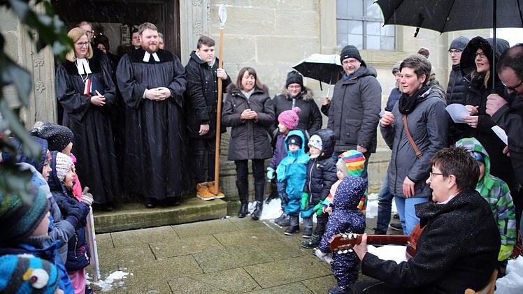 Seit 1. Januar 2018 ist Tobias Knötig "Pfarrer auf Lebenszeit". Am Sonntag wurde der Heilgersdorfer Geistliche von Dekanin Stefanie Ott-Frühwald (Michelau, links) während eines Festgottesdienstes in der Kirche "Zu unserer lieben Frauen" in seinem Amt installiert. Beim Verlassen des Gotteshauses brachten Kinder der evangelischen Kita "Schneckenhaus" dem Pfarrer ein Ständchen. Foto: Bettina Knauth