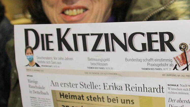 Erika Reinhard hält ihre Titelseite hoch.