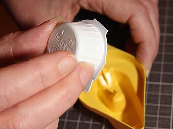 Das verschlossene Kaffeesahne-Portionsdöschen wird kopfüber auf den Kaffeesahne-Öffner gedrückt. Im Inneren des gelben Kaffesahne-Öffners ist ein kreuzförmiger Dorn, der lässt die Milch in die Auffangschale fließen, von wo aus sie problemlos und ohne Spritzer in die Tasse gegossen werden kann.....