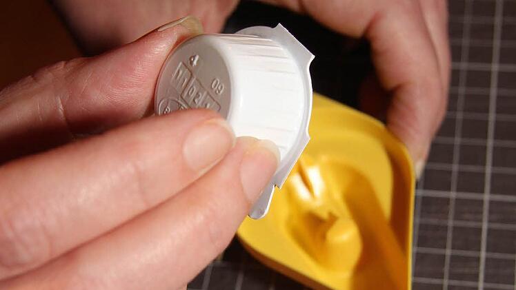 Das verschlossene Kaffeesahne-Portionsdöschen wird kopfüber auf den Kaffeesahne-Öffner gedrückt. Im Inneren des gelben Kaffesahne-Öffners ist ein kreuzförmiger Dorn, der lässt die Milch in die Auffangschale fließen, von wo aus sie problemlos und ohne Spritzer in die Tasse gegossen werden kann.....