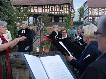 Bei der ersten Station am Dorfbrunnen verteilten Helferinnen und Helfer ein Glas Wasser an jeden Besucher und der Landfrauenchor sang "Vöglein in hohem Baum". Foto: Nelly Ritz
