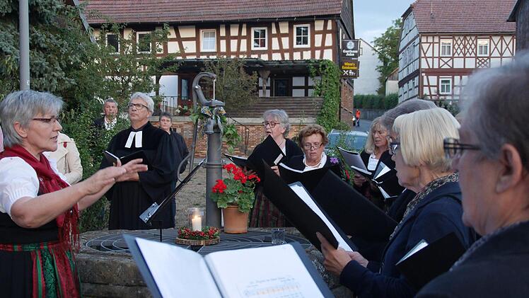 Bei der ersten Station am Dorfbrunnen verteilten Helferinnen und Helfer ein Glas Wasser an jeden Besucher und der Landfrauenchor sang "Vöglein in hohem Baum". Foto: Nelly Ritz