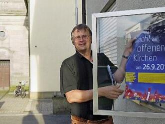 Stefan Ahr hängt Werbeplakate auf.  Foto: Lindner