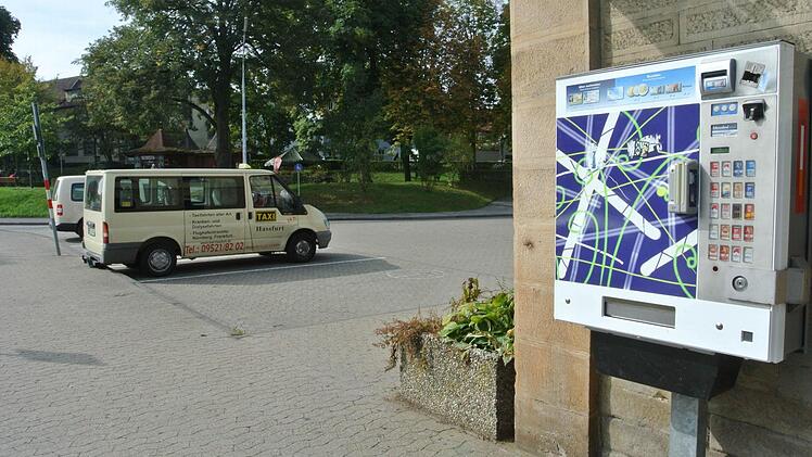 Vor dem Bahnhof warten Taxis. Der Haßfurter Bahnhof ist ein zentraler Anlaufpunkt im Öffentlichen Personennahverkehr.