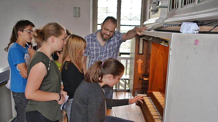 Einmal an der Orgel spielen?  Wer wollte, der durfte das in der evangelischen Kirche ausprobieren. Pfarrer Lutz Mertten gab dann Hilfestellung und erklärte die Funktionen der "Königin der Instrumente". Foto: Hanns Friedrich